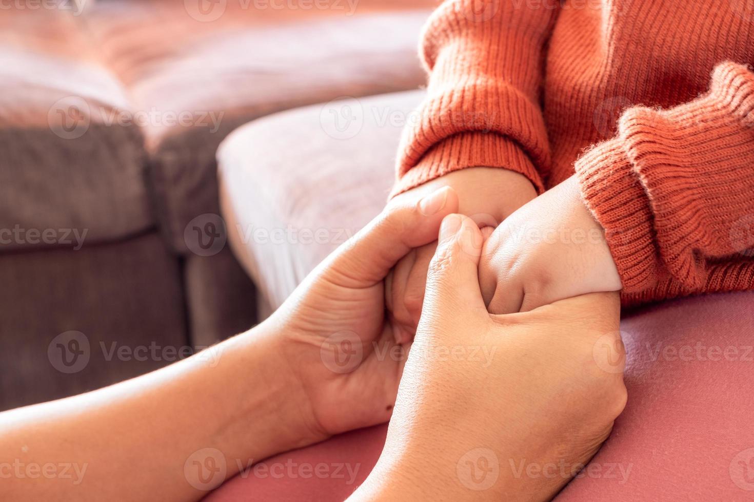 Close up of mother holding baby hand at home for encourage and hope, happy family concept photo