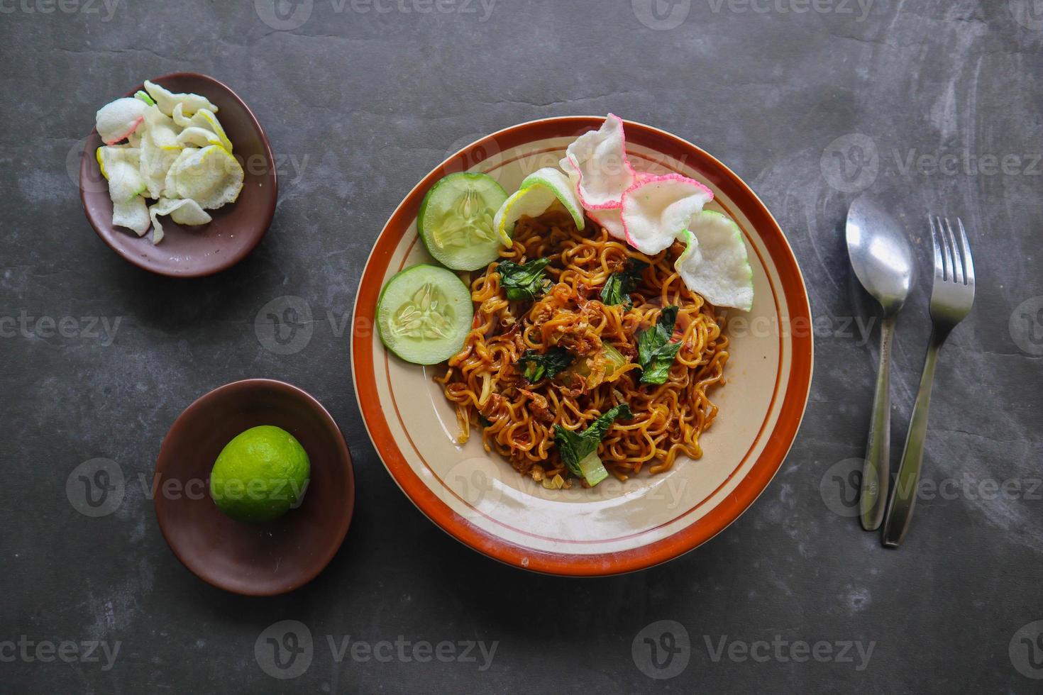 mie tek tek or fried noodle made with egg noodles with chicken, cabbage, mustard greens, meatballs, scrambled eggs. indonesian food photo