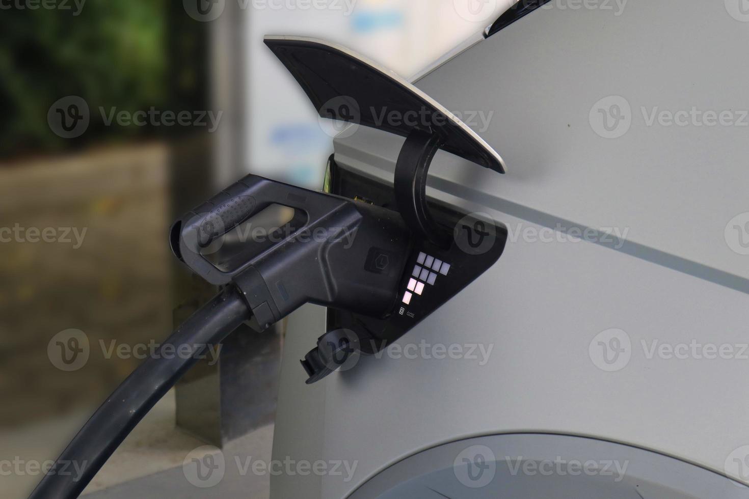 EV Car or Electric car at charging station with the power cable supply plugged photo