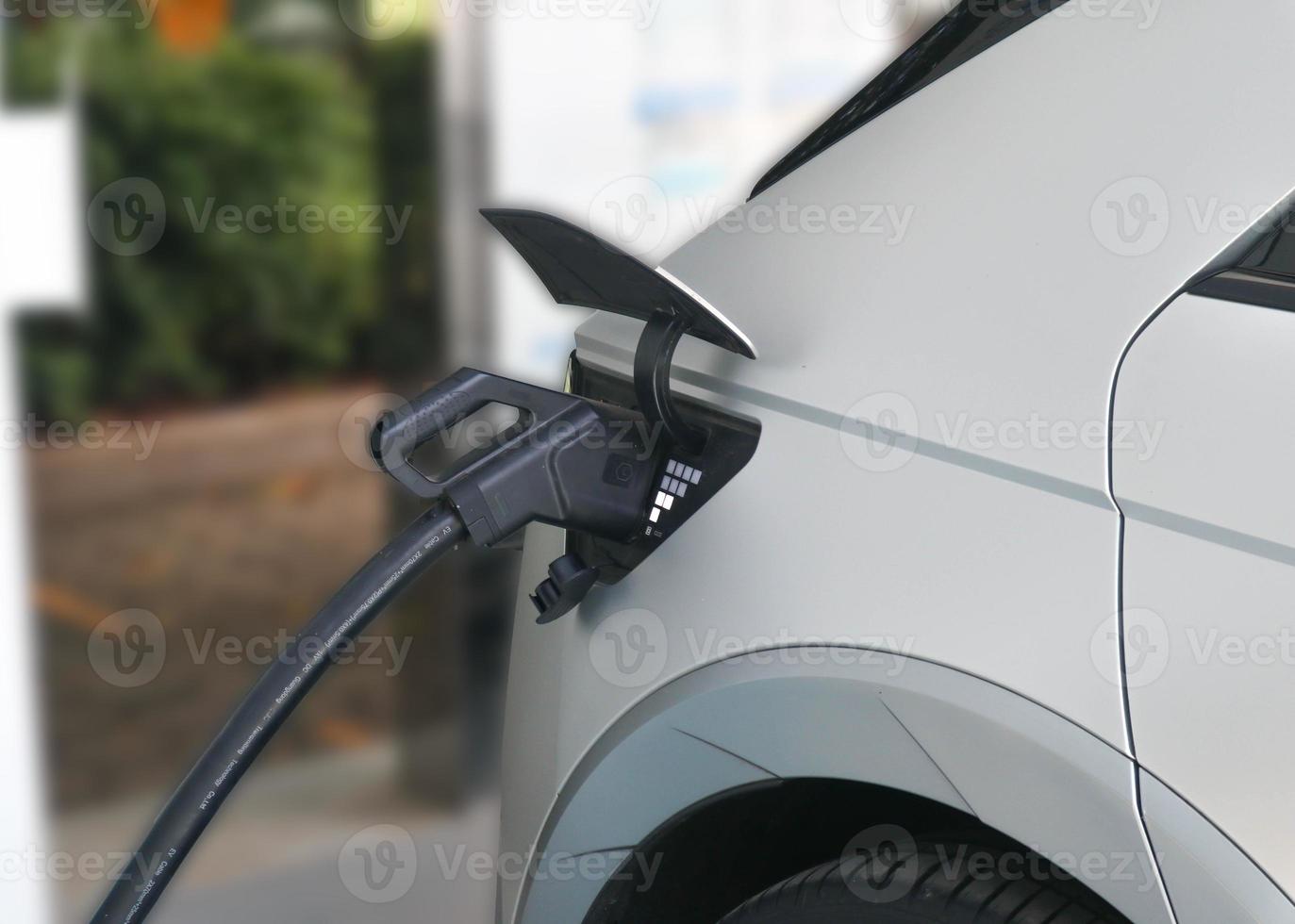 EV Car or Electric car at charging station with the power cable supply plugged photo