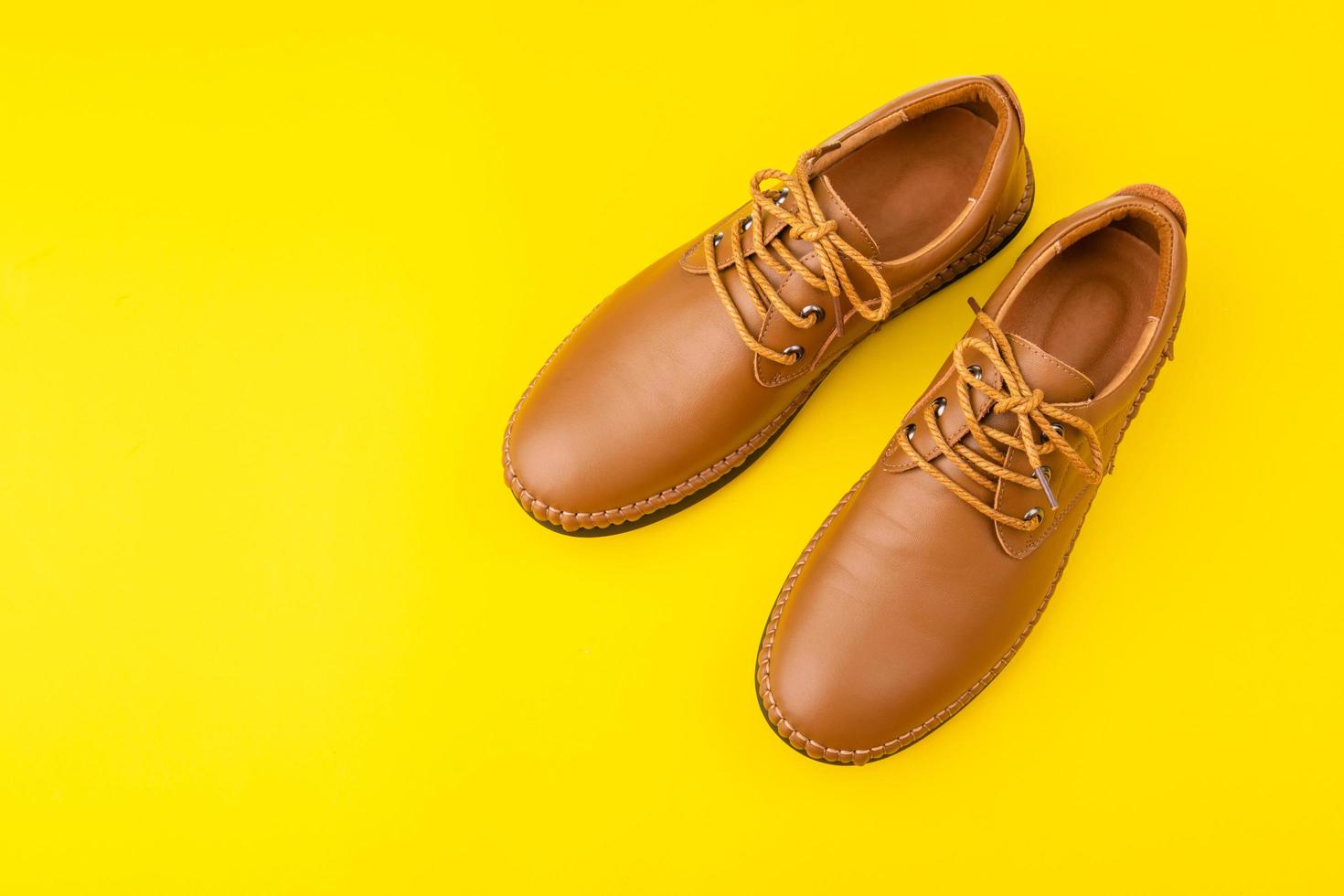 New brown men leather shoes. Studio shot isolated on yellow photo