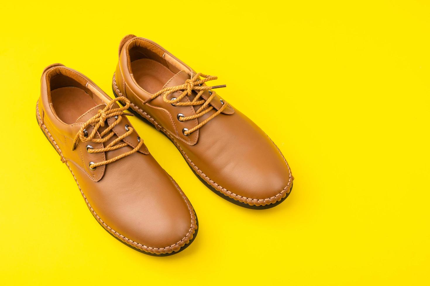 New brown men leather shoes. Studio shot isolated on yellow photo