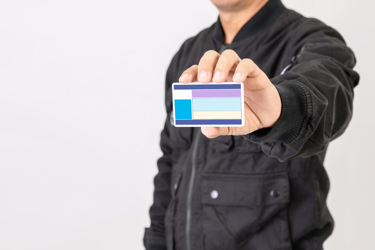 Portrait rider in black jacket holding and show blank Thailand driving licence. Over 400cc motorcycle in Thailand need especially licence. Studio shot isolated on grey photo