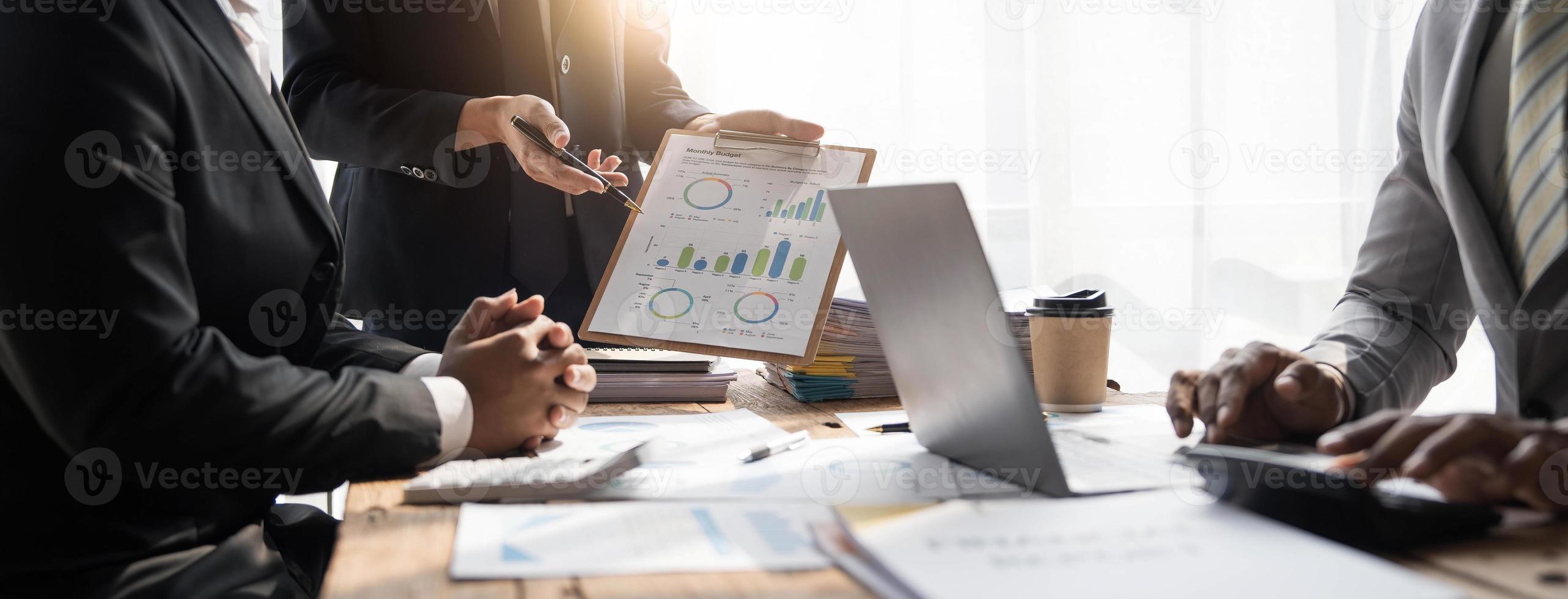 Business People Meeting using laptop computer,calculator,notebook,stock market chart paper for analysis Plans to improve quality next month. Conference Discussion Corporate Concept photo