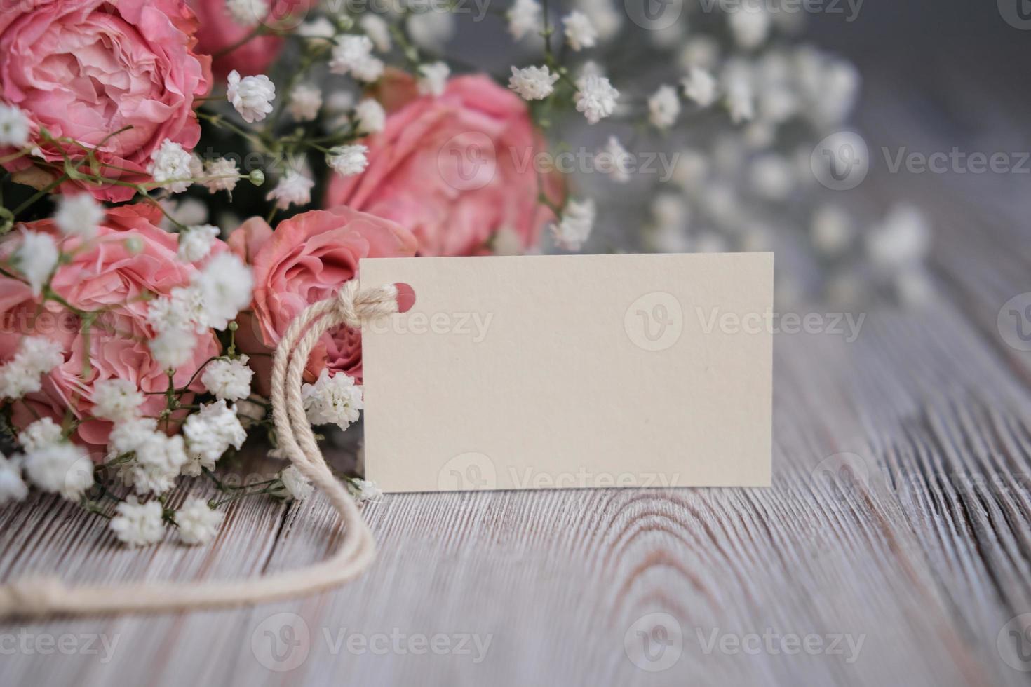 Bouquet of flowers and blank white card for text. Mockup tag. Postcard photo