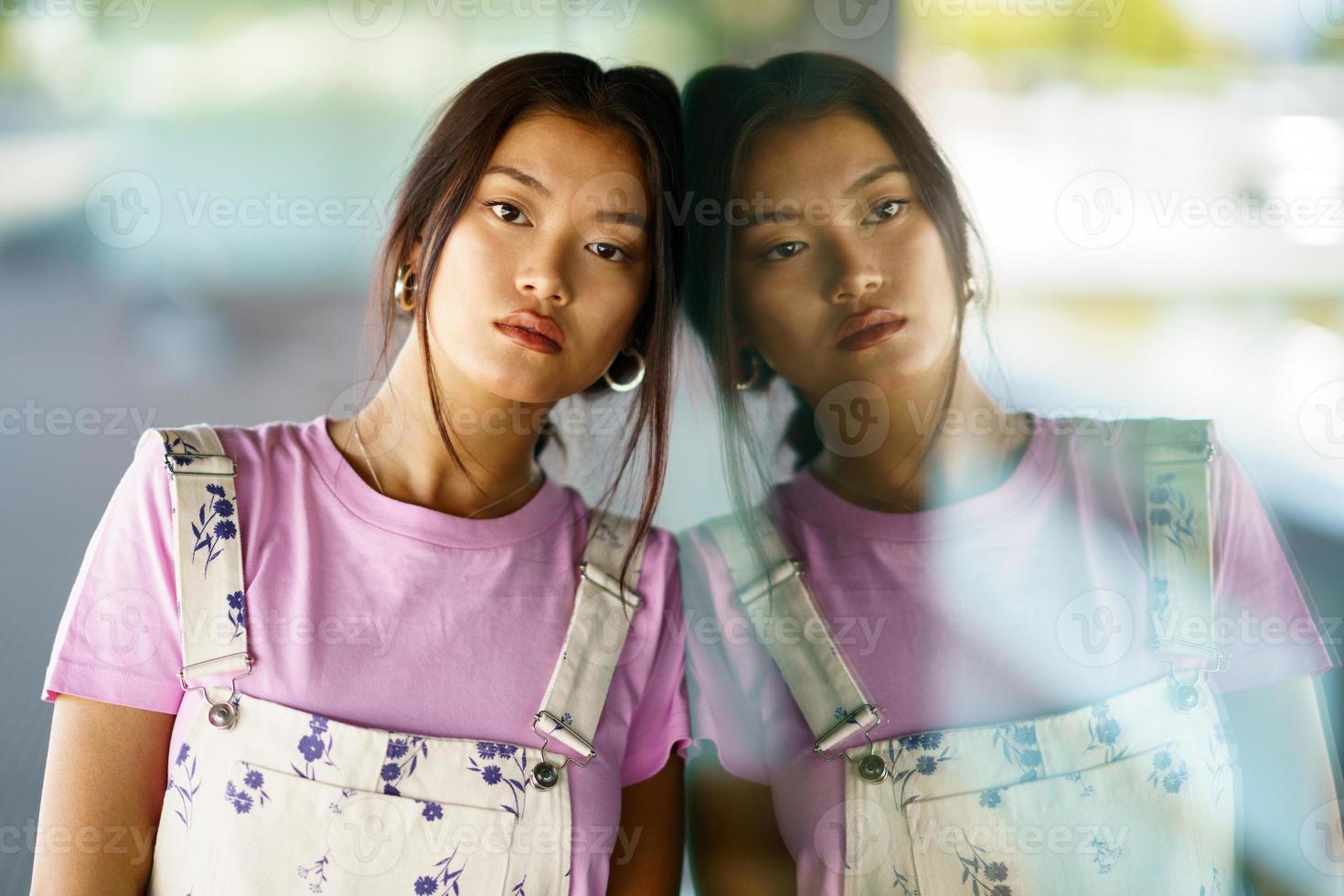 Thoughtful upset Asian woman lost in thoughts outdoors. photo