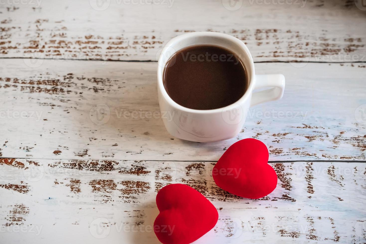 coffee Cup and red hearts on a white wooden background. Valentine's day. photo