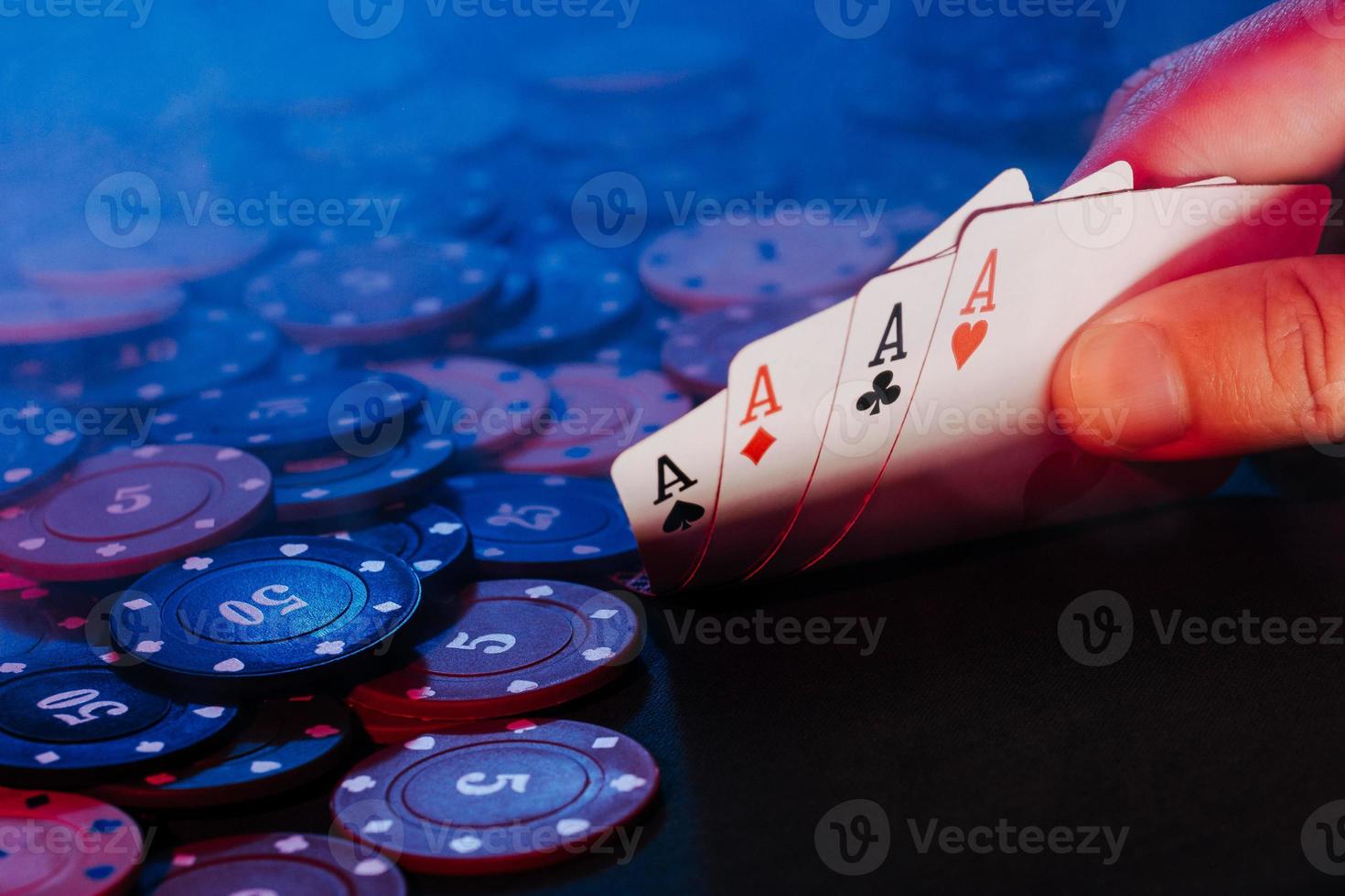 men's hands hold cards against the background of playing chips. there is smoke in the photo