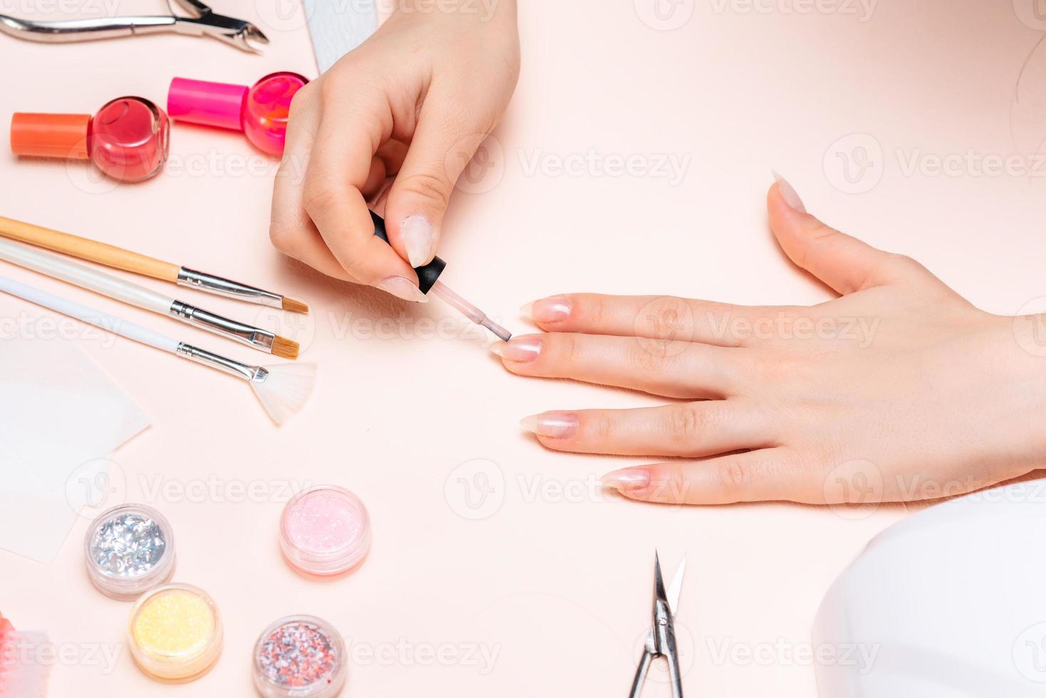 hands of a girl doing a manicure at home, hands close-up. the view from the top photo