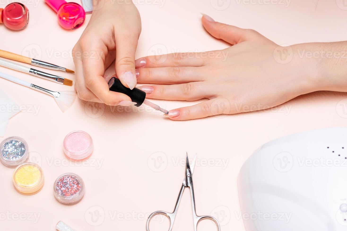 hands of a girl doing a manicure at home, hands close-up. the view from the top photo