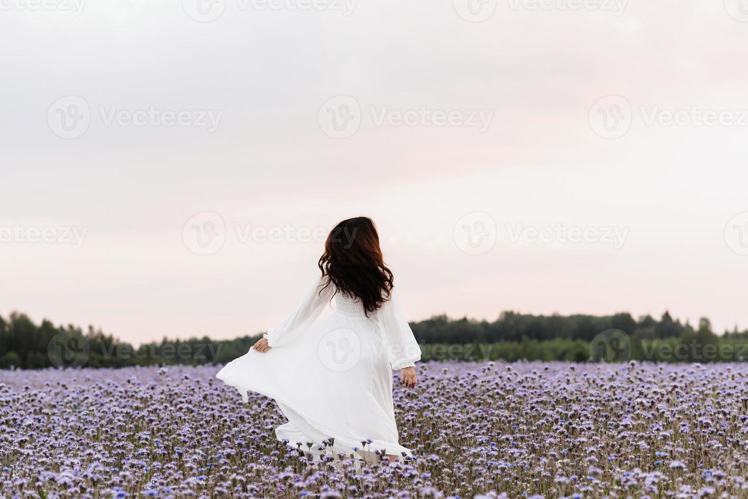 Provence blooming field. The girl is happy and laughs running through the blooming field. photo