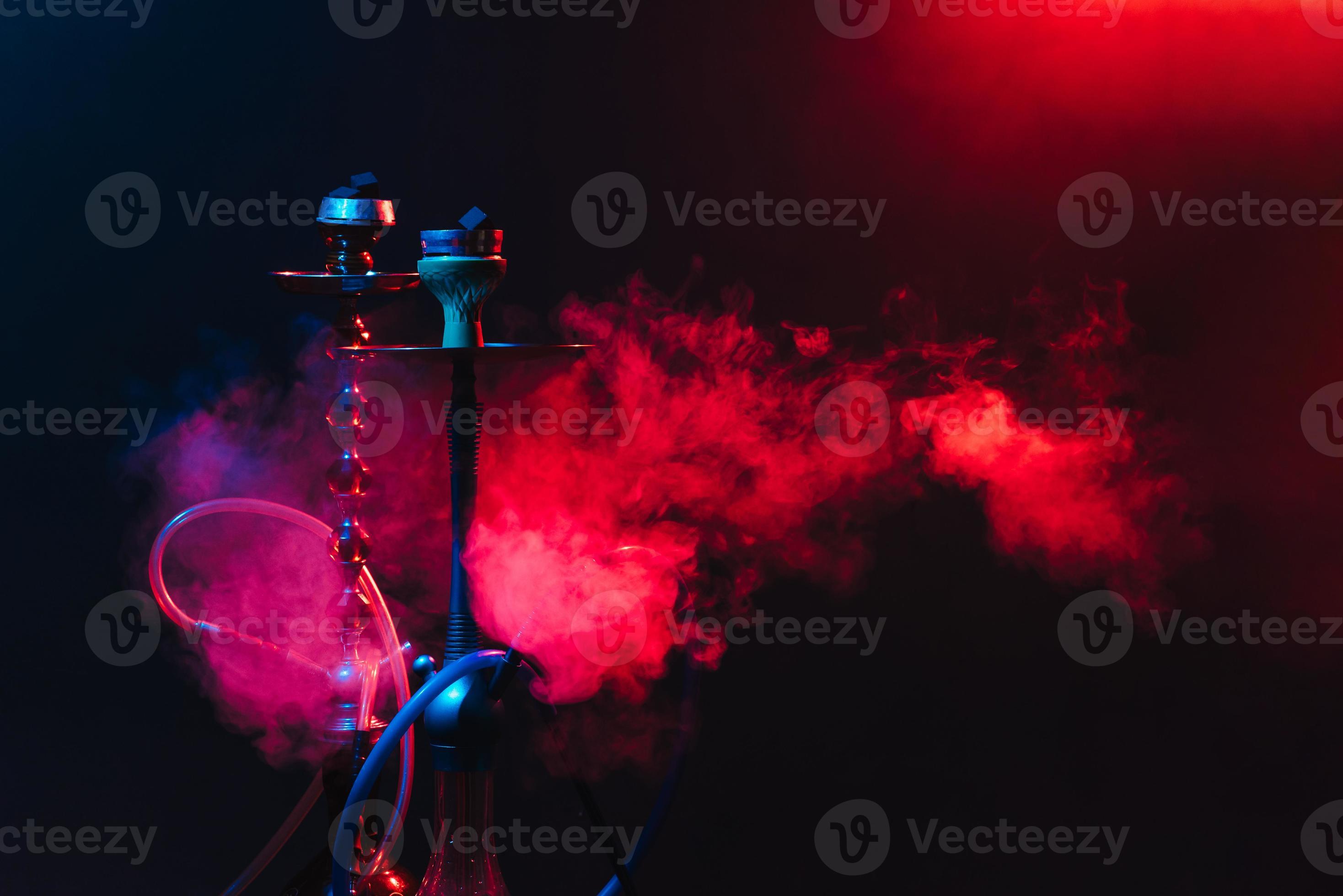 Modern hookah, shisha on a smoky black background with neon lighting
