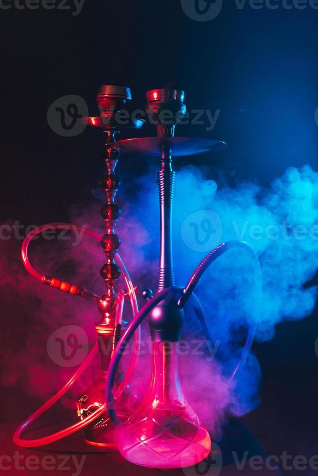 modern hookah, shisha on a smoky black background with neon lighting
