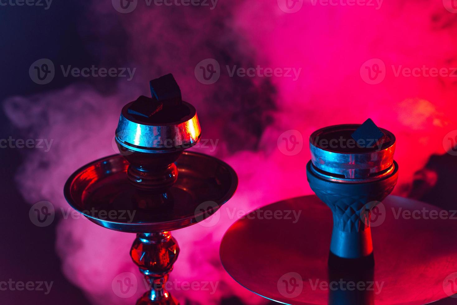 hookah bowl and coals close up on a black background with smoke photo
