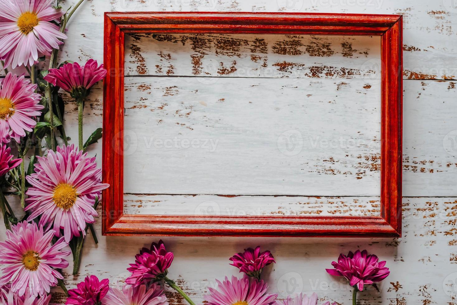 pink chrysanthemums are placed on a white wooden background with space for text and a frame photo