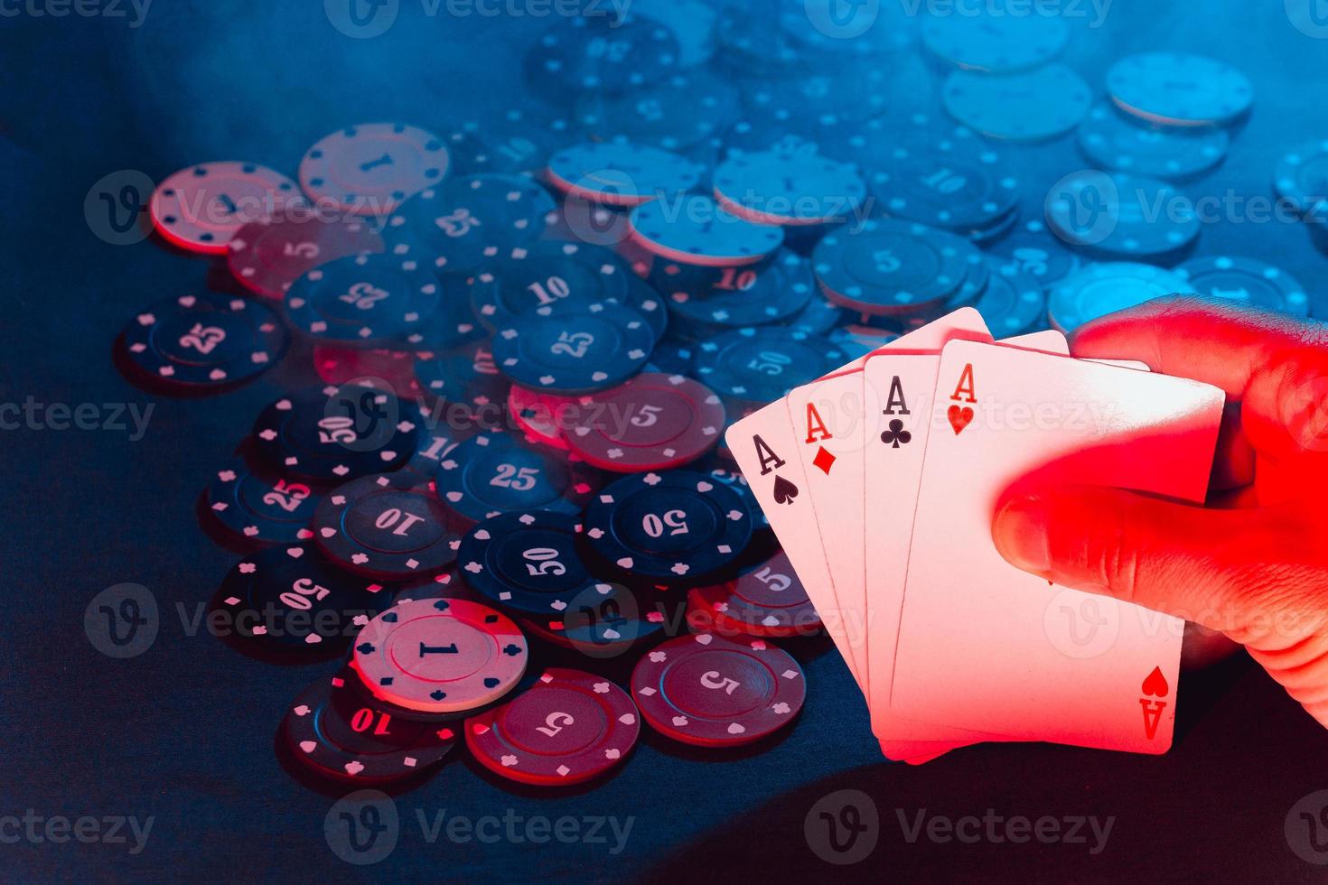 men's hands hold cards against the background of playing chips. there is smoke in the photo