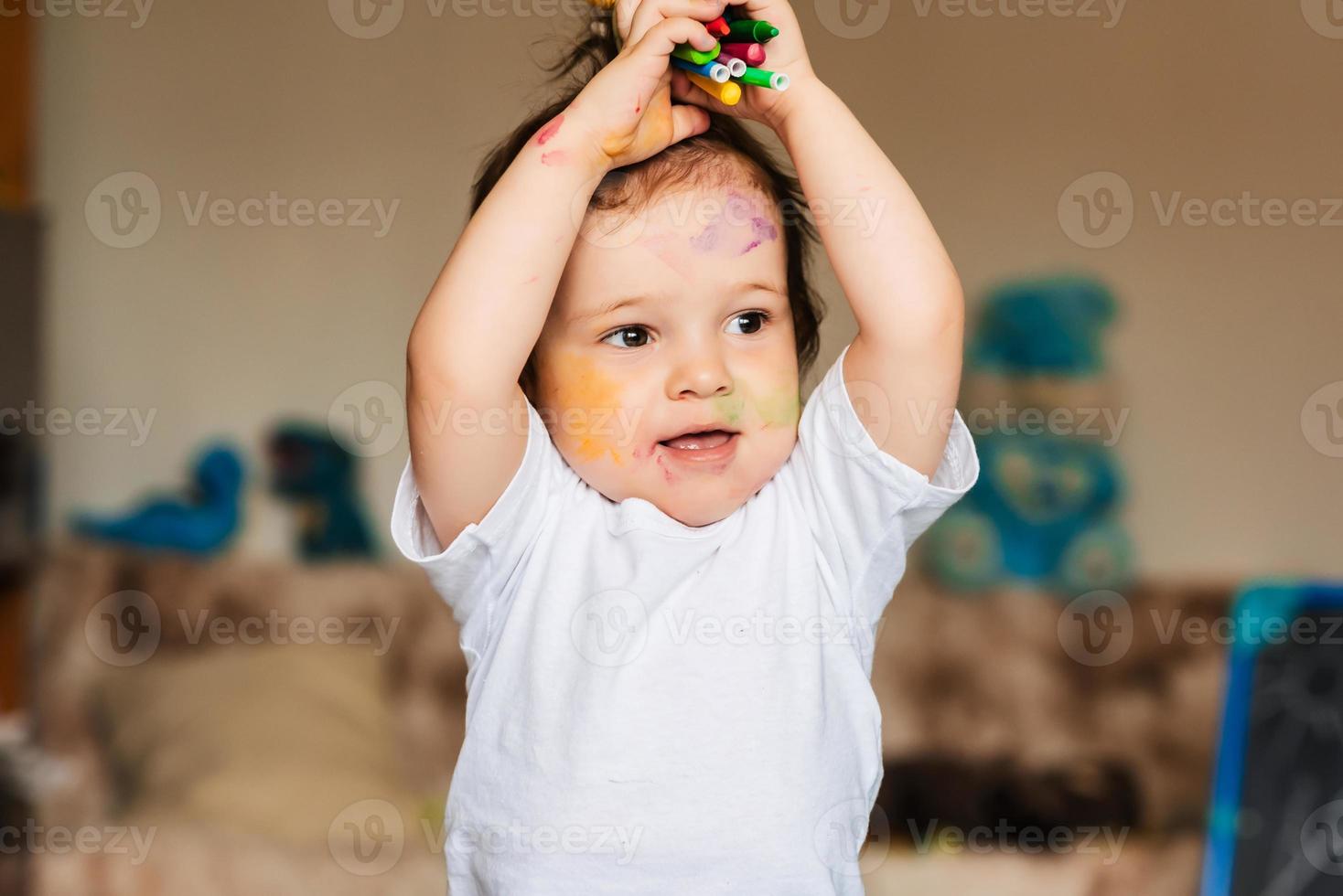 lindo niño sosteniendo lápices de colores y marcadores foto