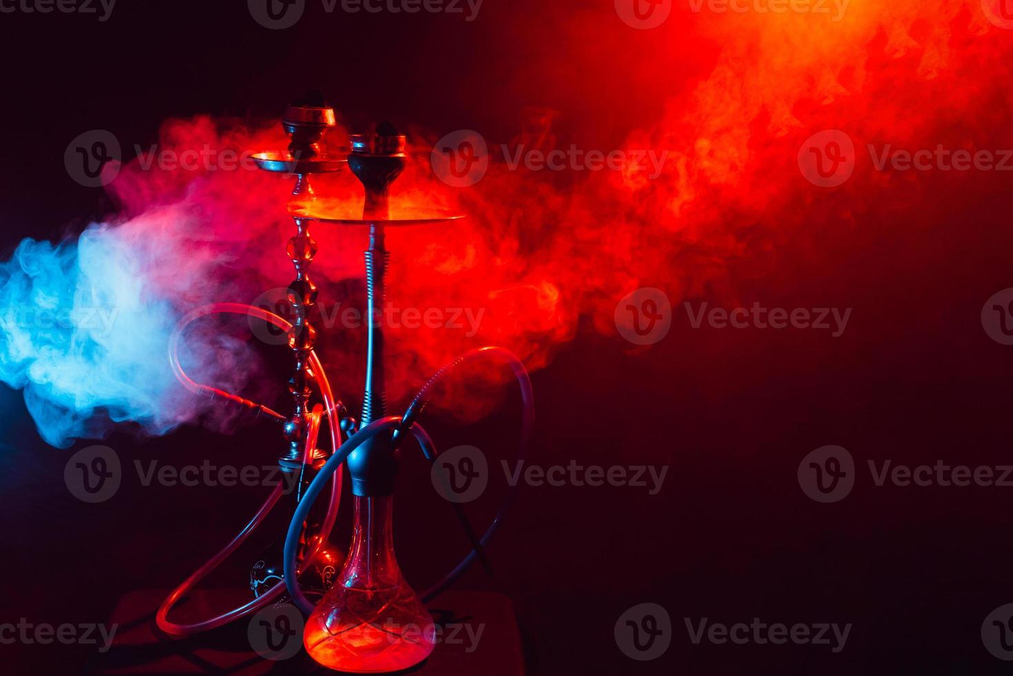 Hookah, shisha on a smoky black background with neon lighting and smoke. Place for your text photo