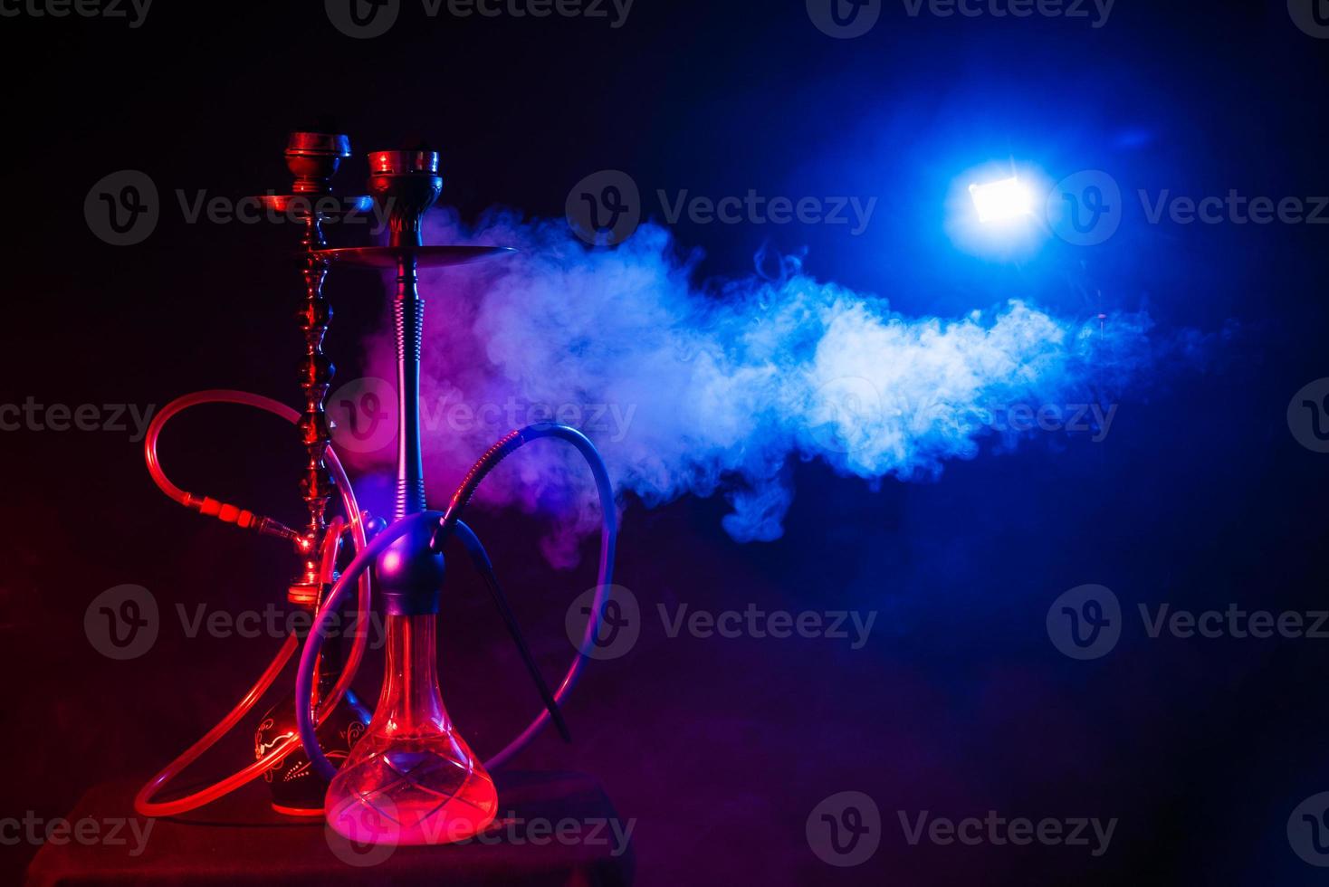 hookah, shisha sobre un fondo negro ahumado con luces de neón y humo. lugar para tu texto foto