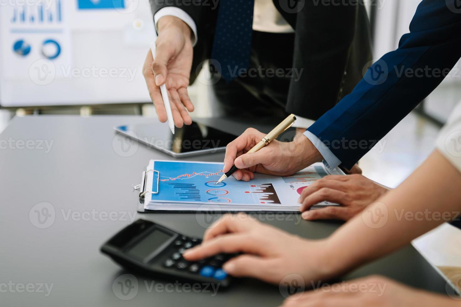 Business team on office table with smart phone and calculator digital tablet and graph business with social network diagram and two colleagues discussing data working in the office photo