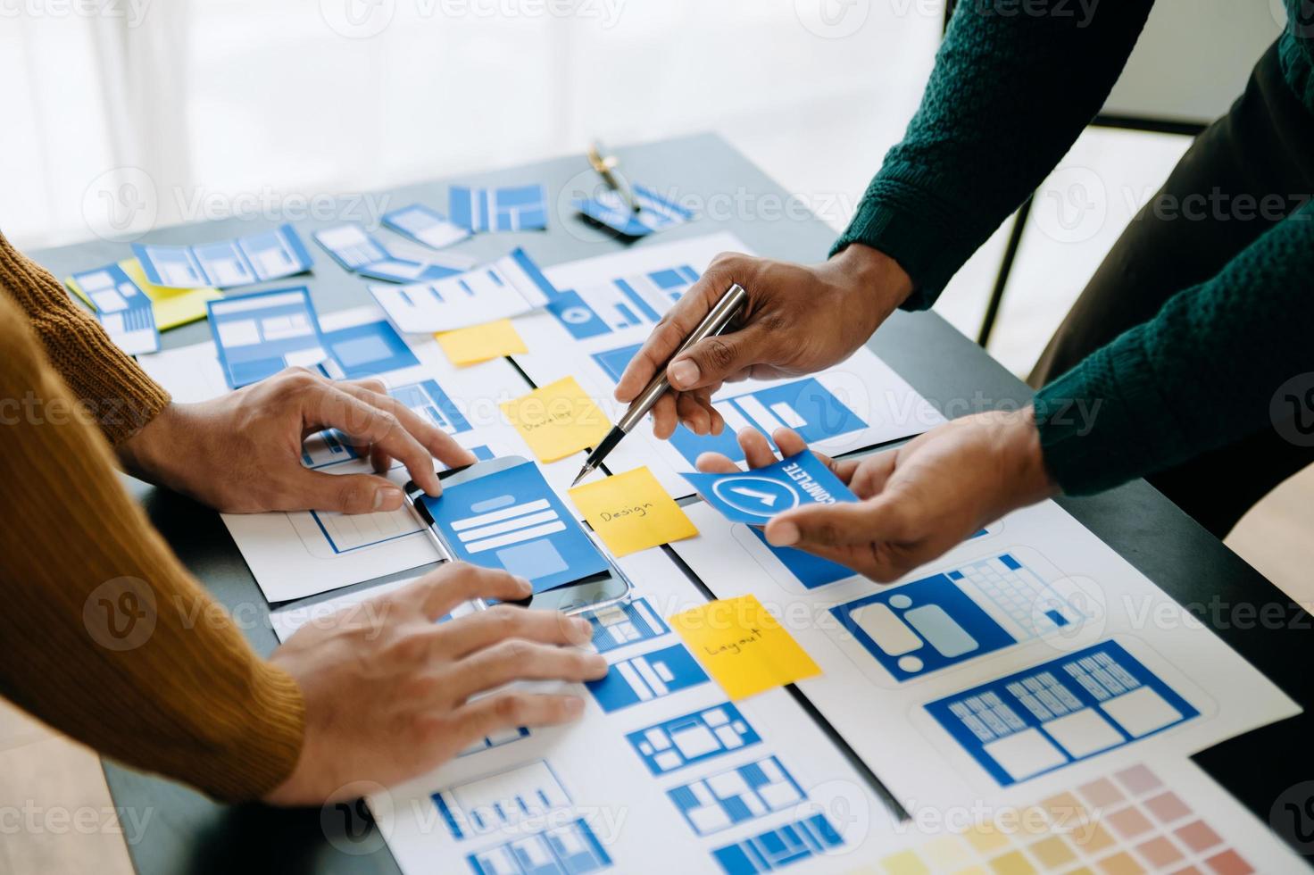UX developer and ui designer brainstorming about mobile app interface wireframe design with customer breif and color code at office. photo