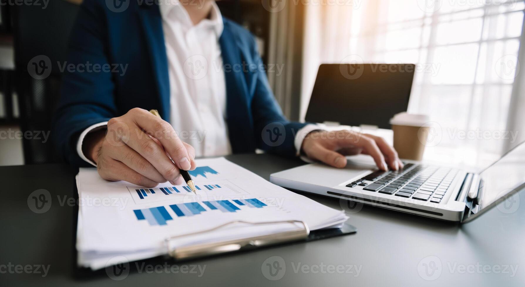 business documents on office table with smart phone and digital tablet and graph financial and woman working at office photo