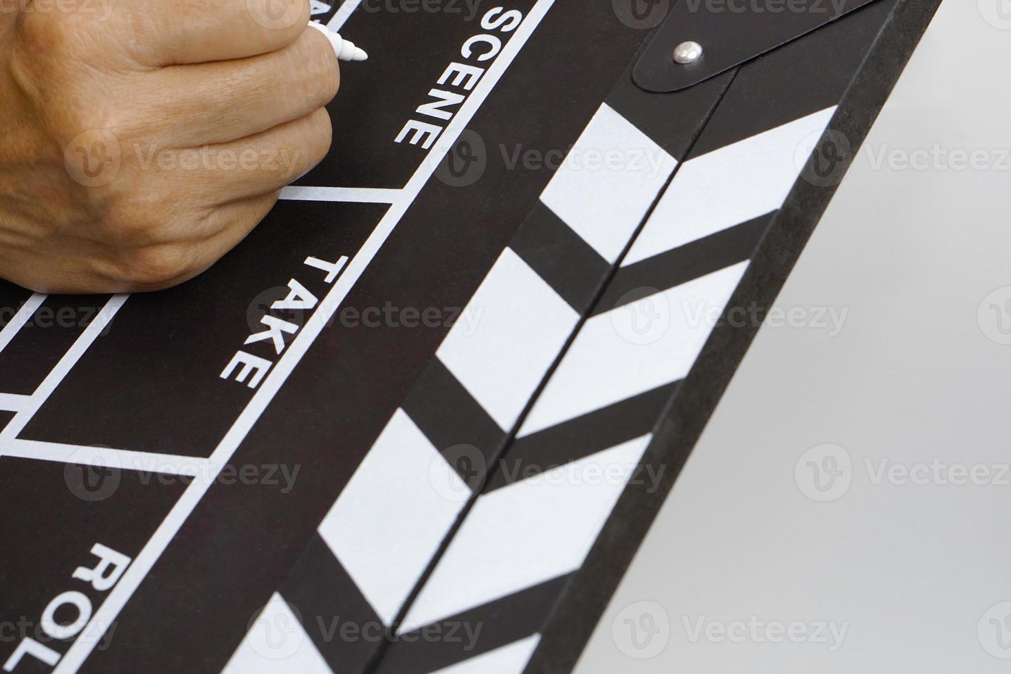 Focus the hand is holding clapperboard or movie slate black color and marker pen. Cinema industry concept. photo