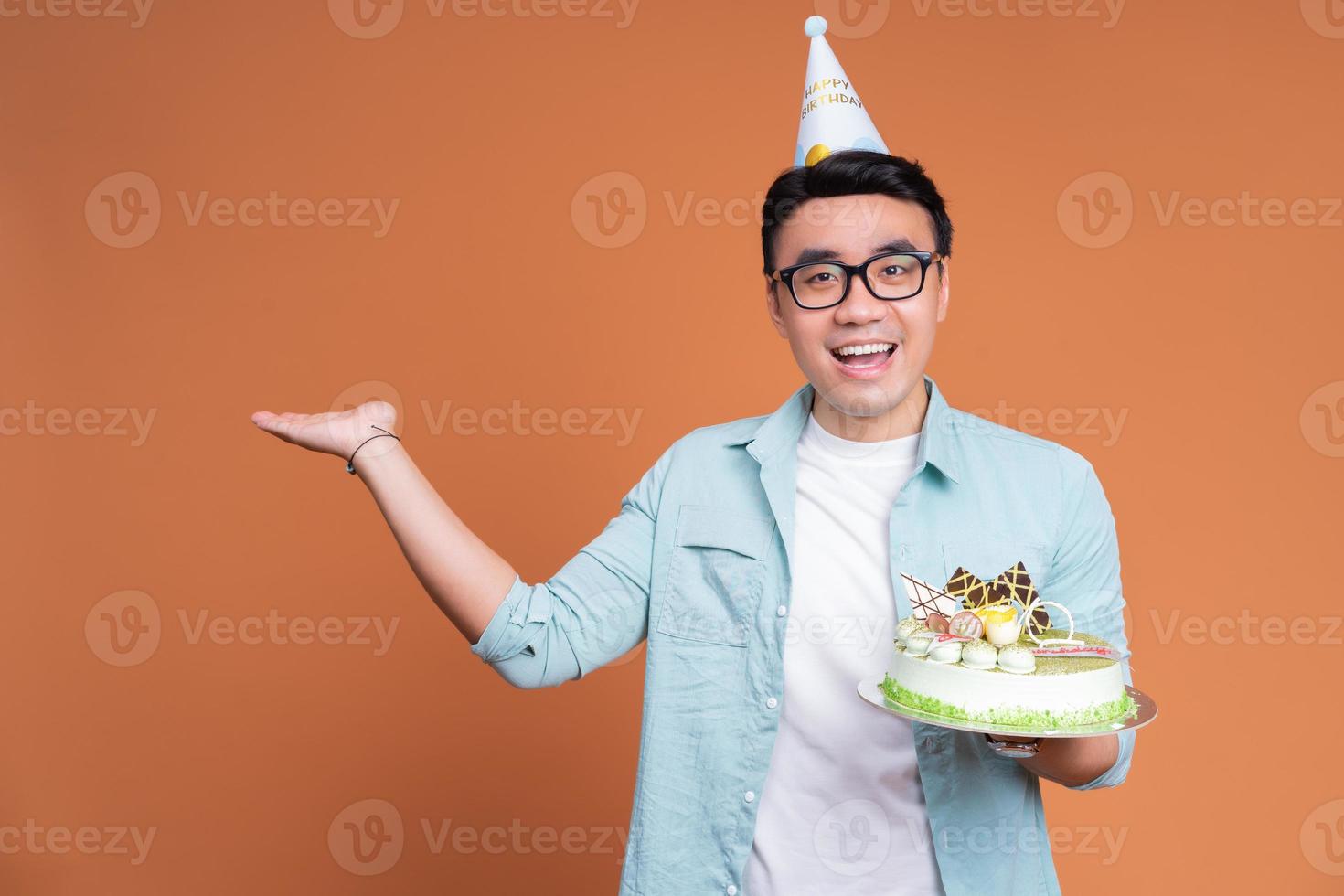 joven asiático sosteniendo pastel de cumpleaños foto
