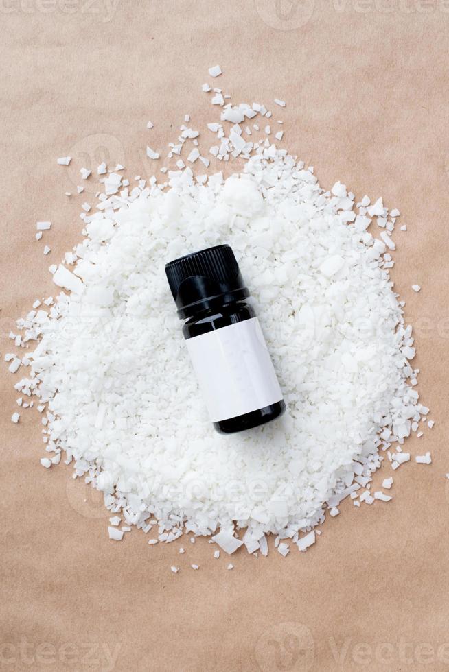mockup of essential oil bottle for candle making on soy wax flakes photo