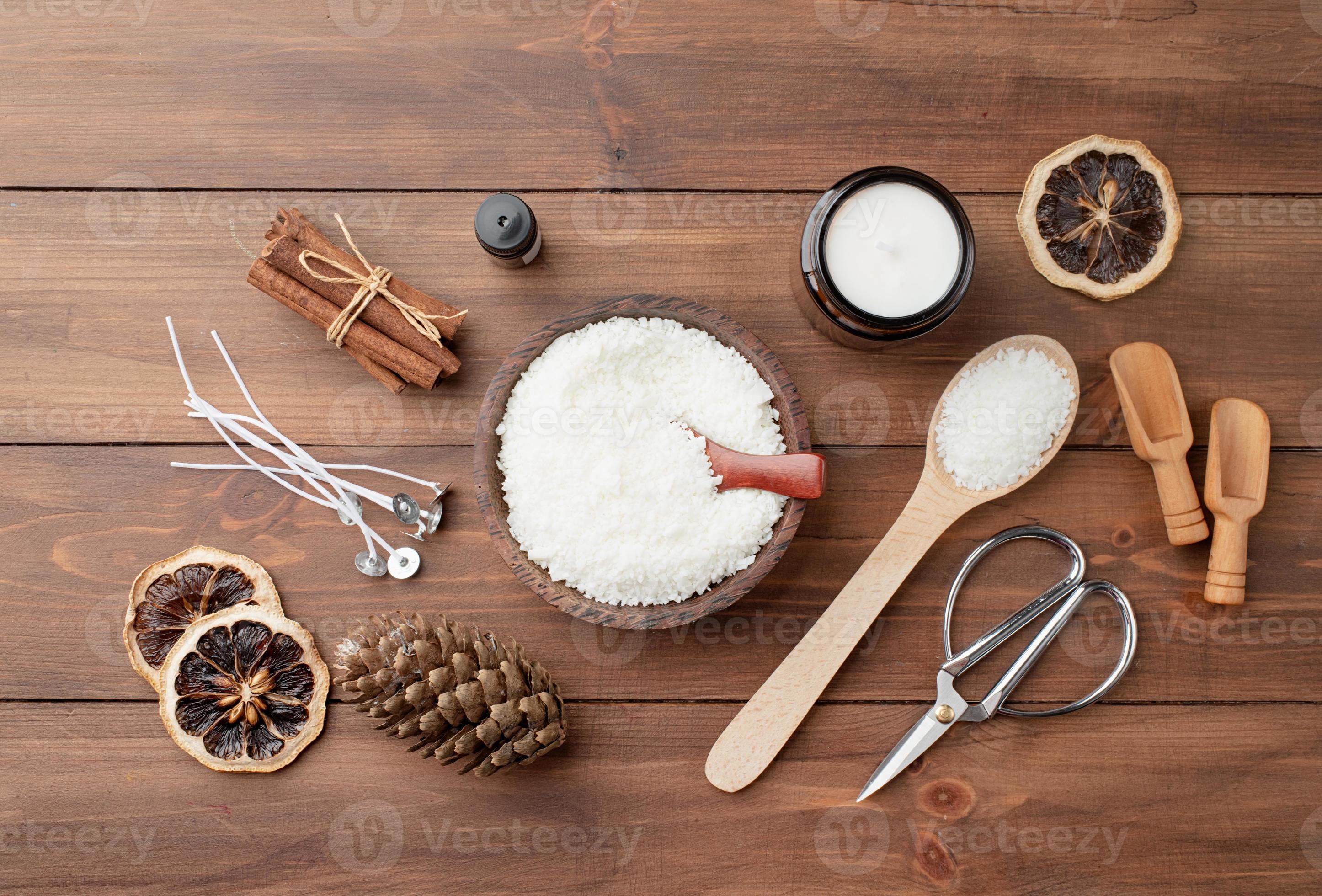 Wooden spoon on heap of soy wax flakes, top view. Homemade candle material  Stock Photo