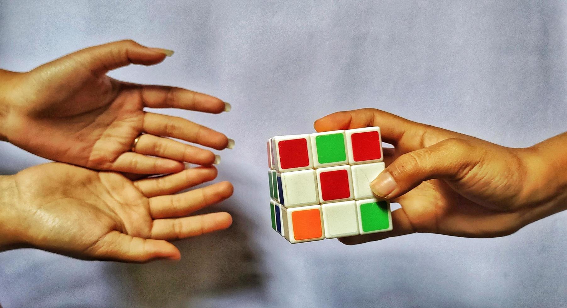 Jakarta, December 2022. An illustration concept of a human hand that will pick up a rubik's cube and play with it photo