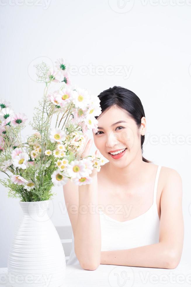 Beauty image of young Asian woman with flowers photo