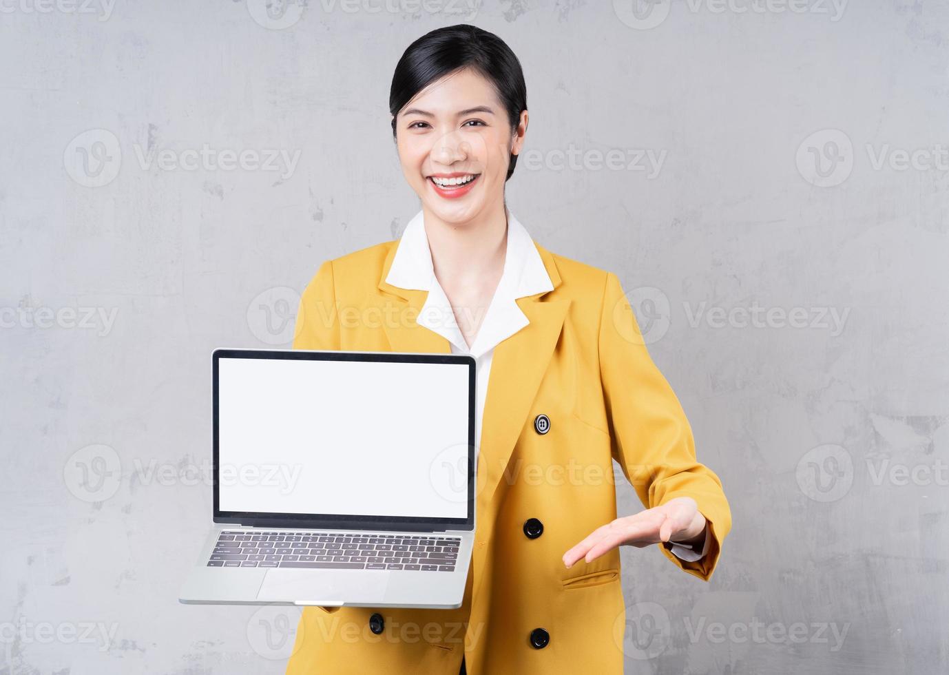 Photo of young Asian woman holding laptop