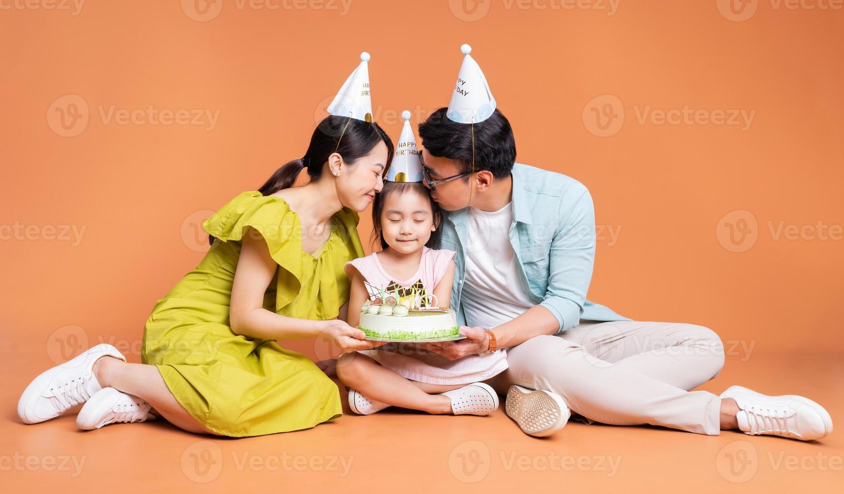 Young Asian family posing on background photo