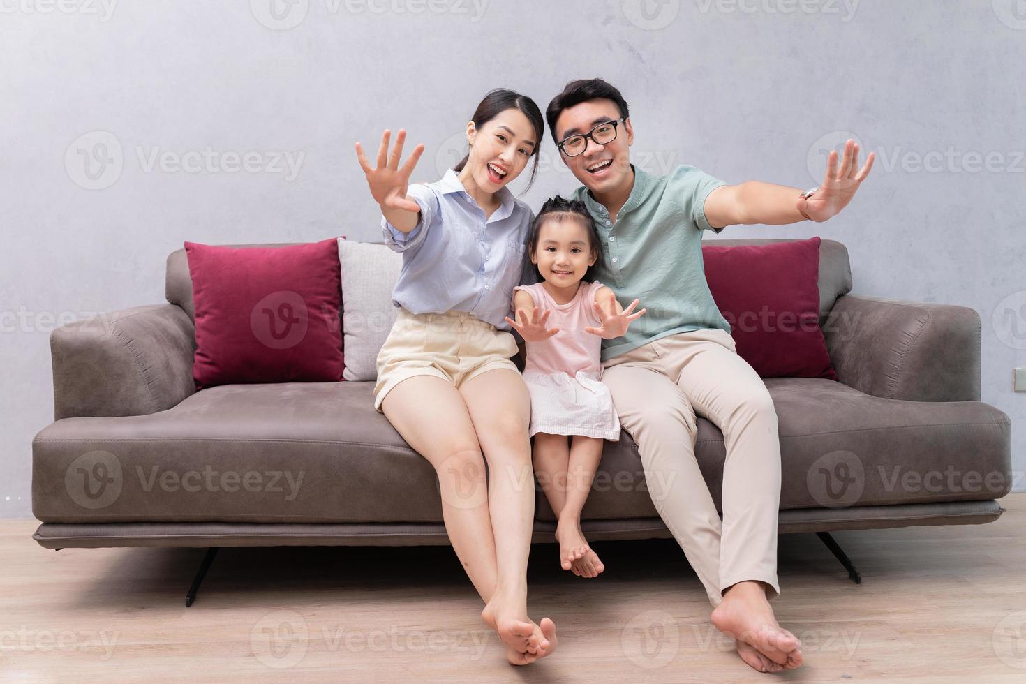 Young Asian family sitting on sofa photo