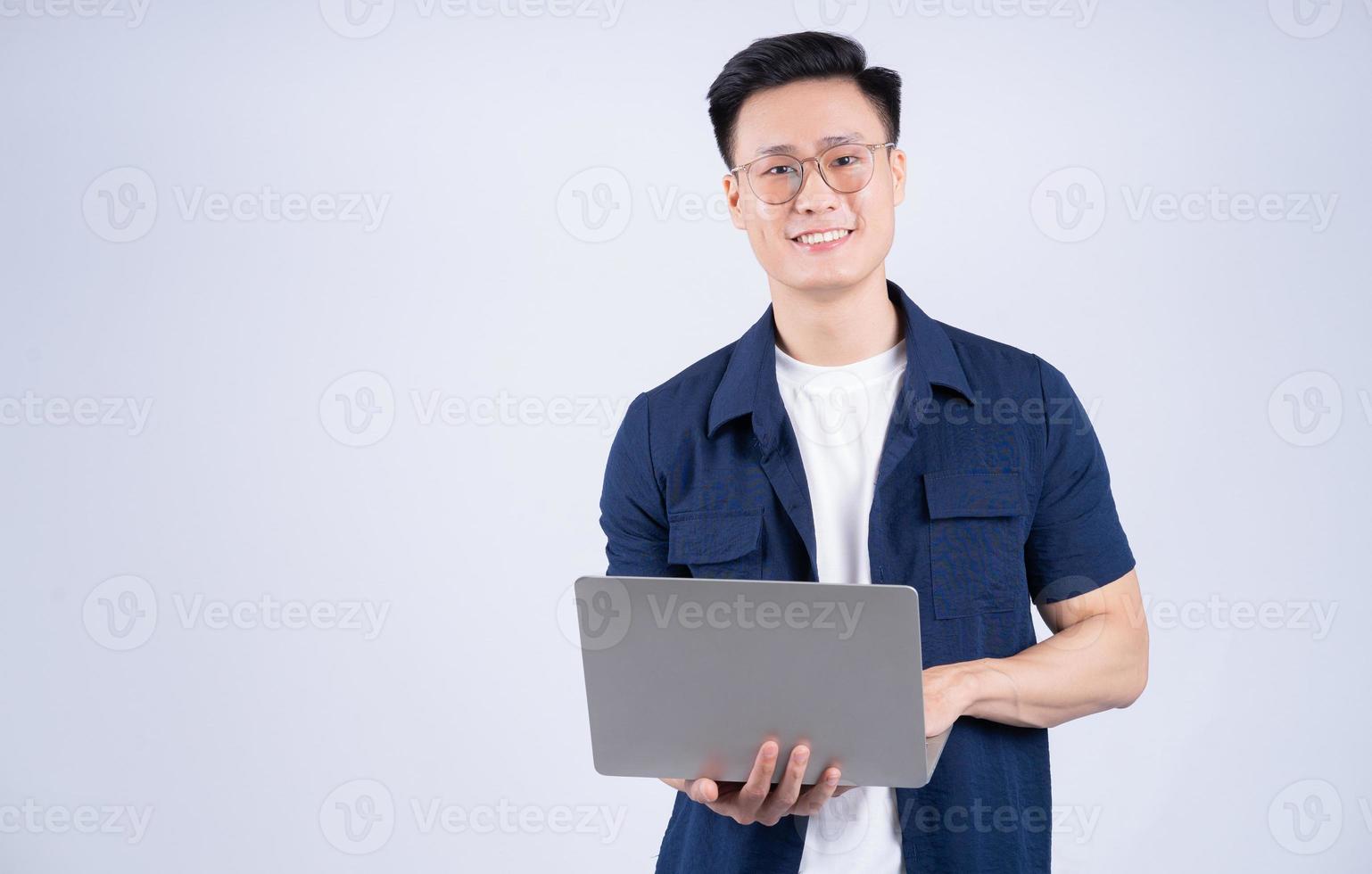 Young Asian man using laptop on white background photo