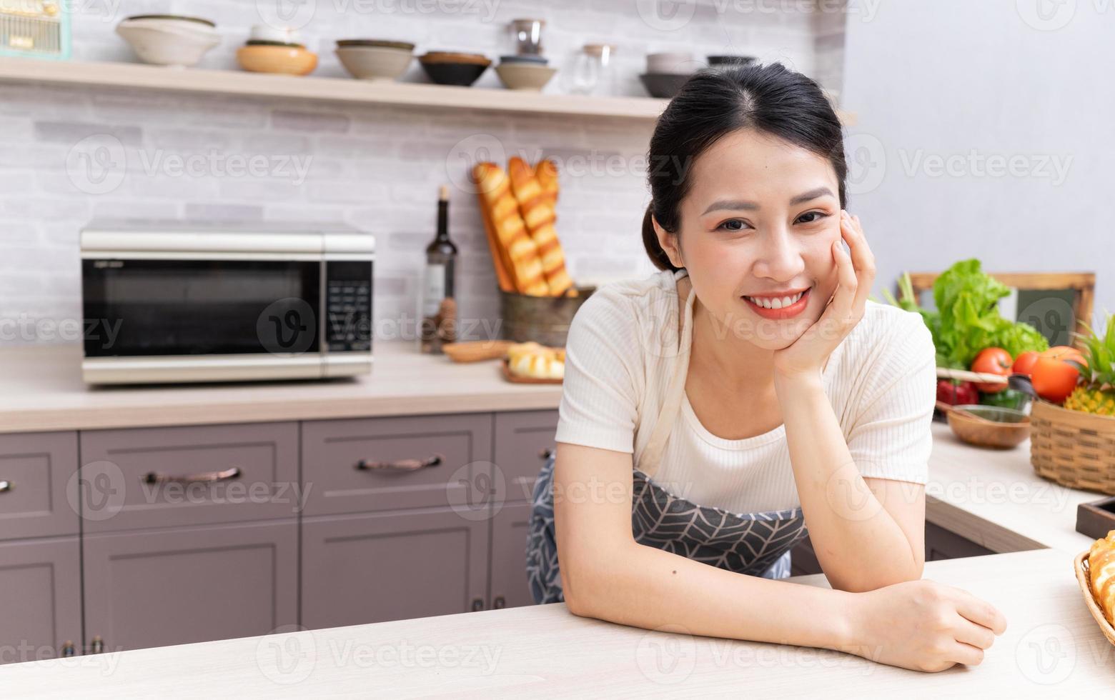 Young Asian woman preparing to cook in the kitchen photo
