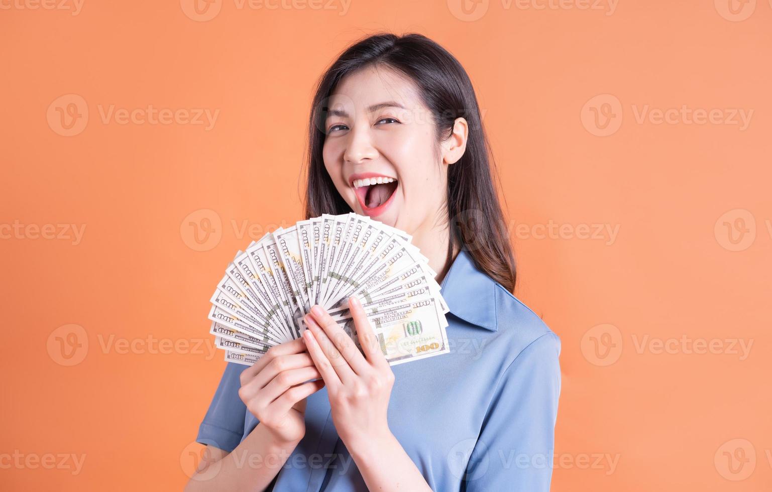 Young Asian business woman posing on orange background photo