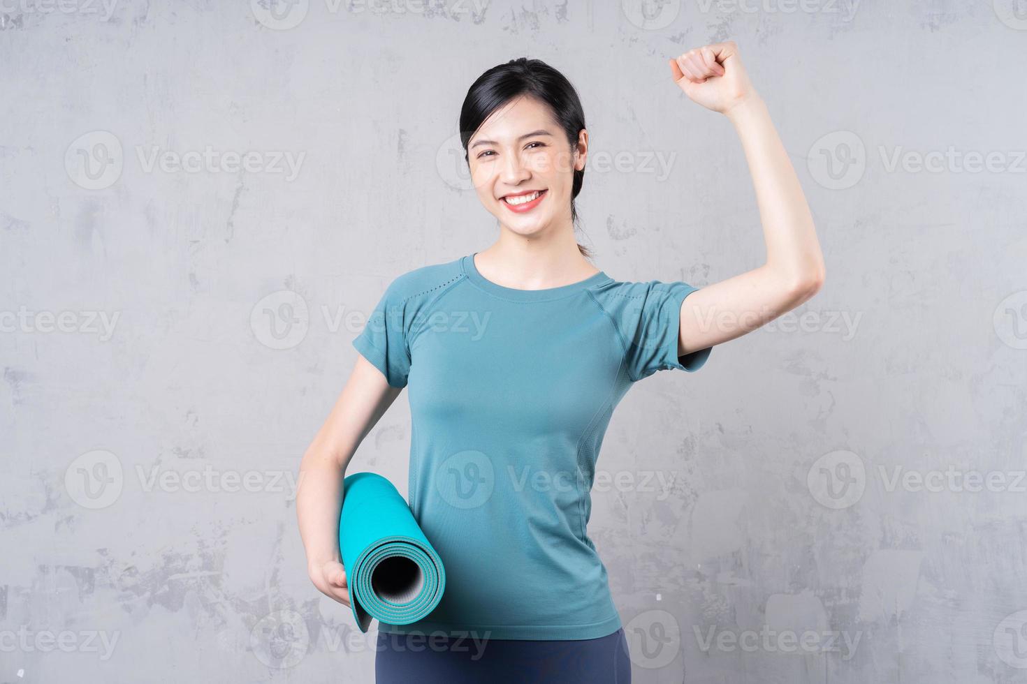 image of young Asian woman holding yoga carpet photo