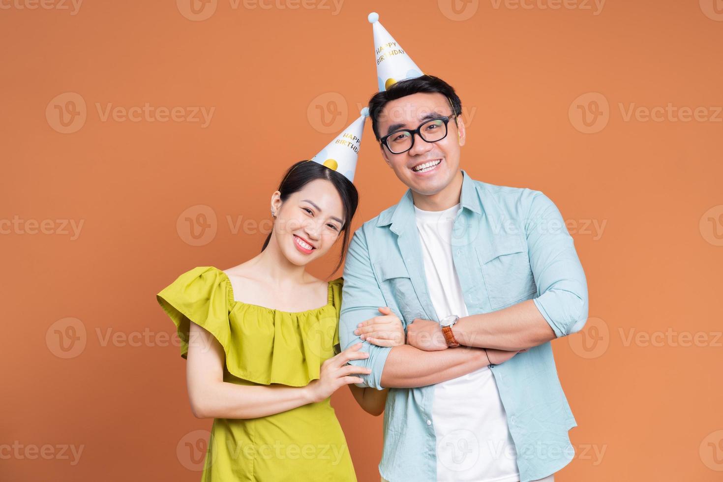 Young Asian couple holding birthday cake on background photo