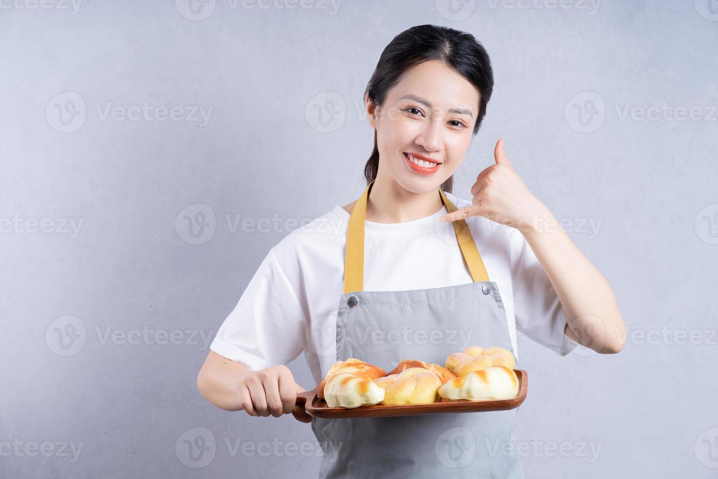 Young Asian woman holding bread on background photo