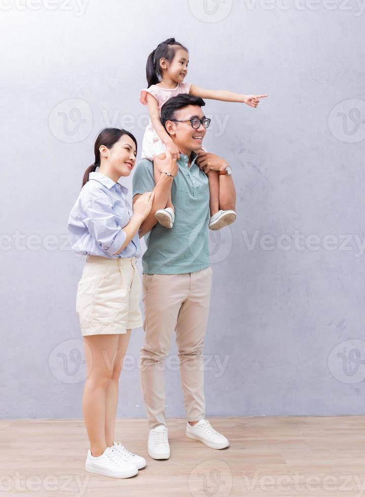 Young Asian family standing on background photo