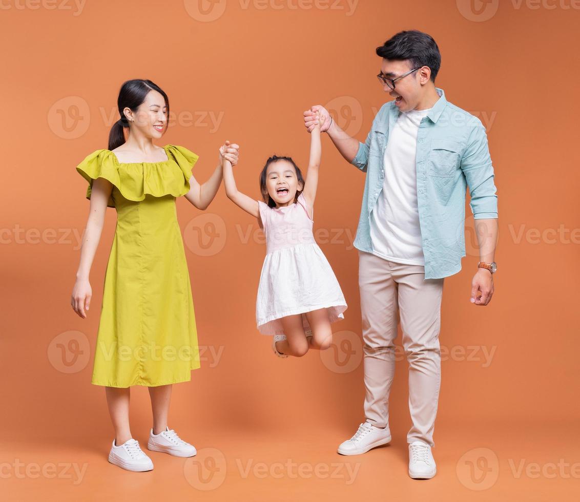 Young Asian family posing on background photo
