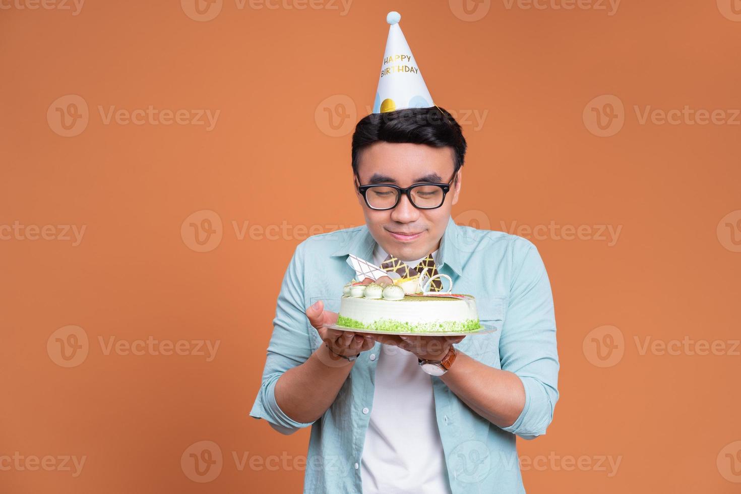 joven asiático sosteniendo pastel de cumpleaños foto