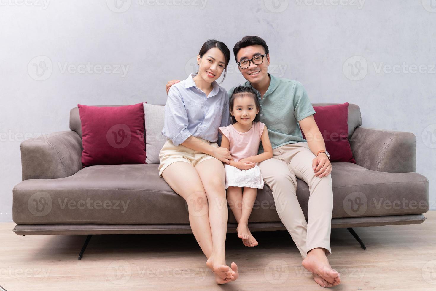Young Asian family sitting on sofa photo