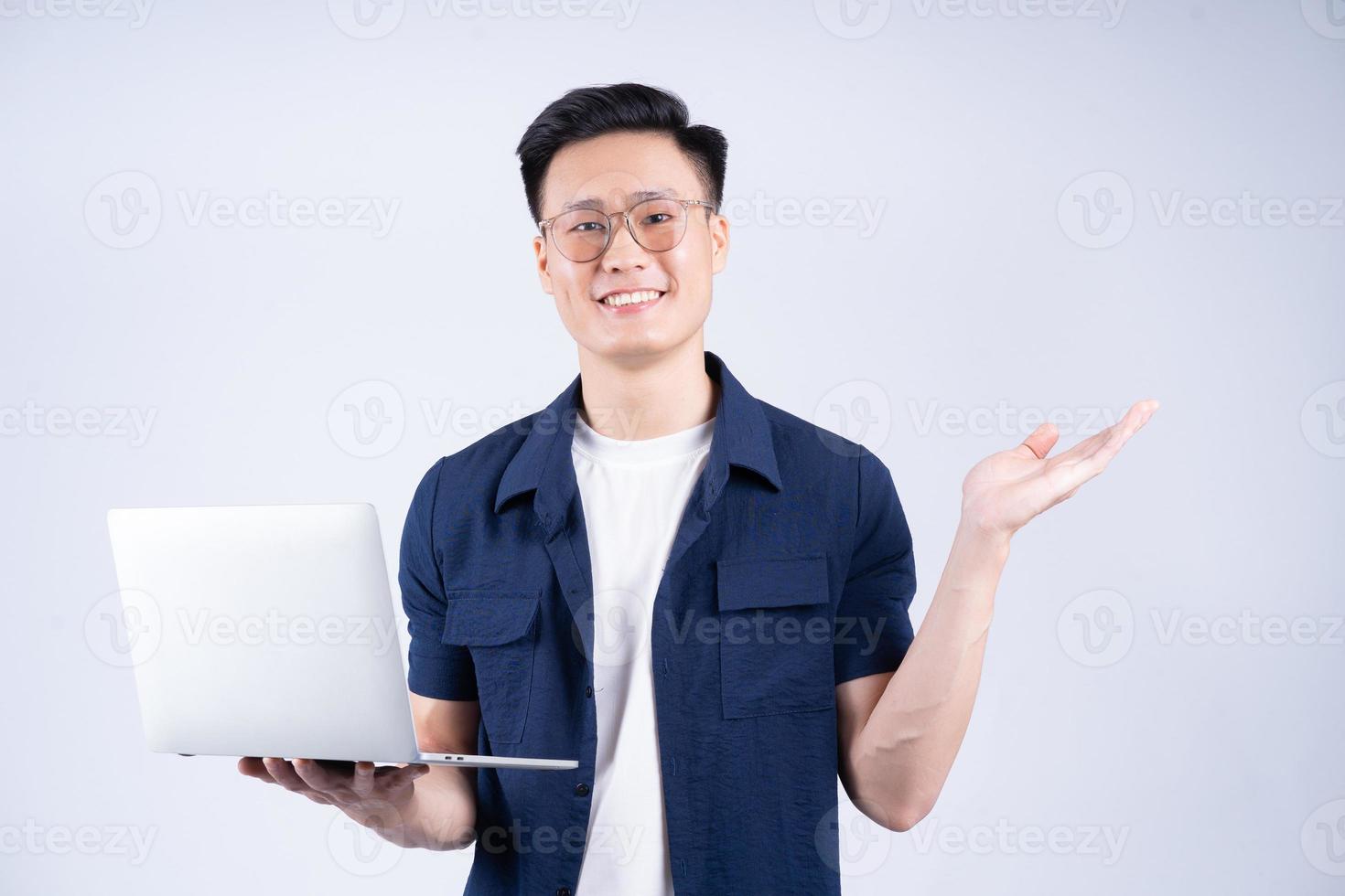 Young Asian man using laptop on white background photo