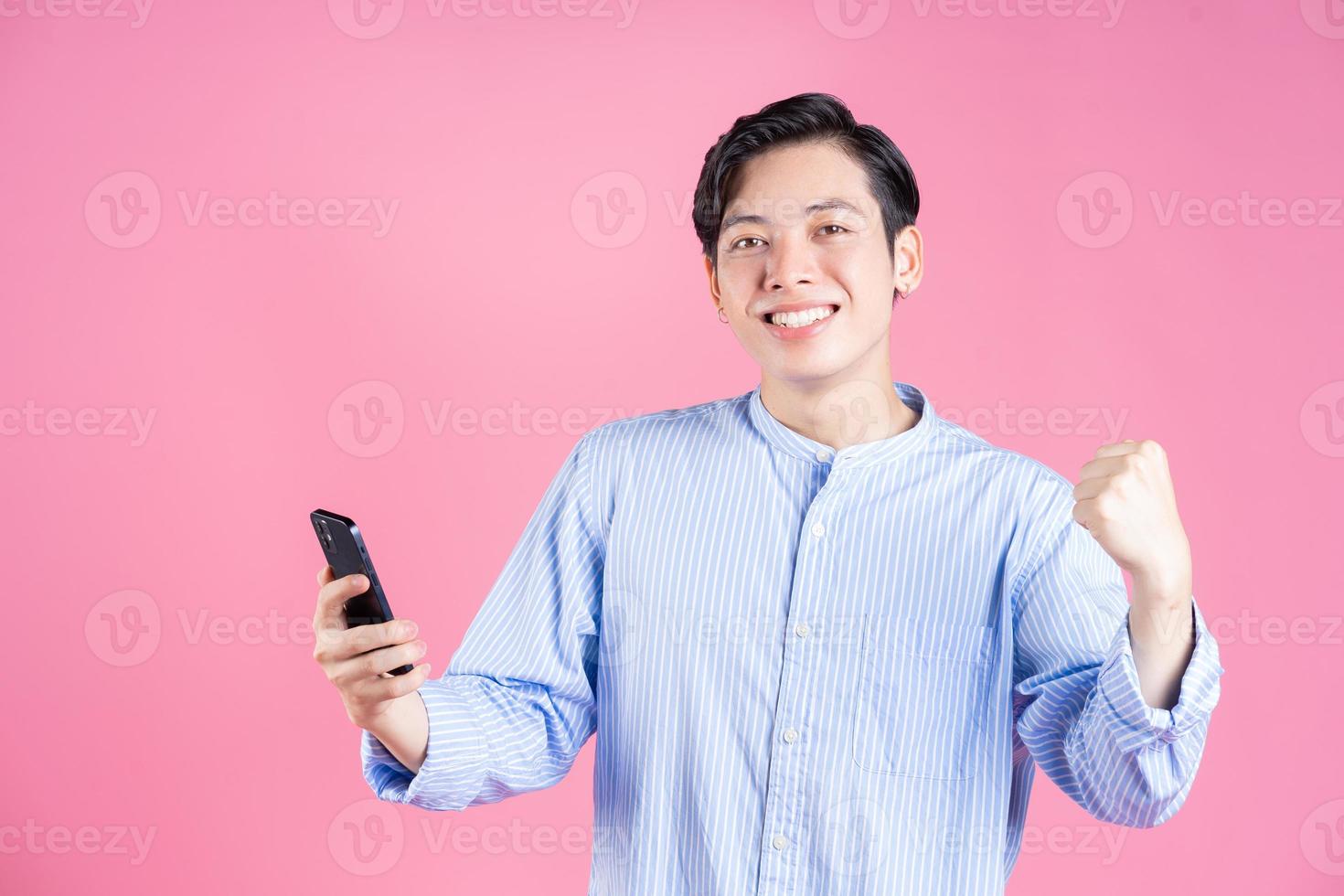 Photo of young Asian man using smartphone on background