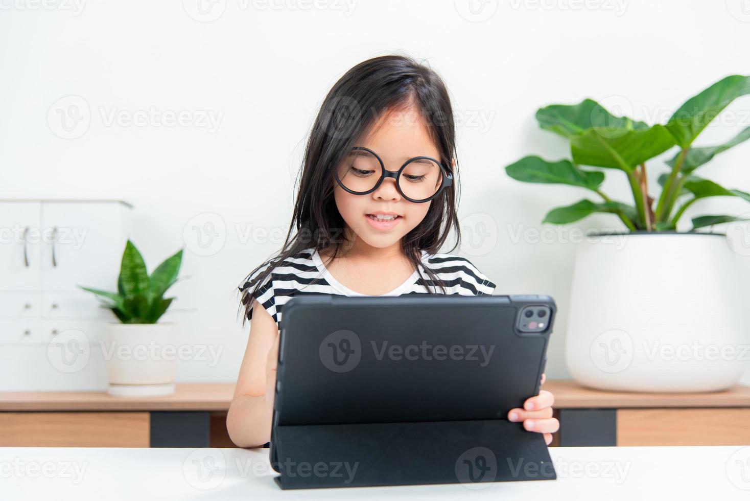 Asian child girl student wow excited on video call learning to studying online class or person learn from home school with tablet photo