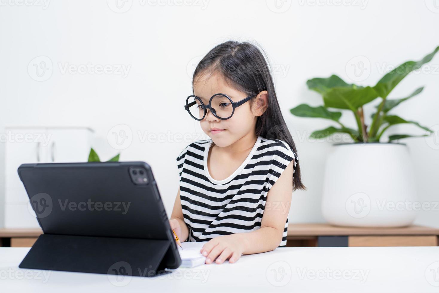 Asian child girl student wow excited on video call learning to studying online class or person learn from home school with tablet photo