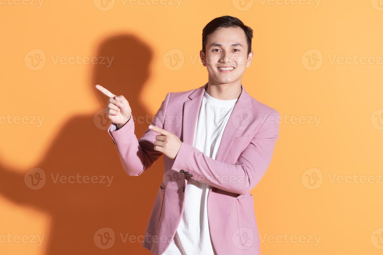 Portrait of young Asian man posing on background photo